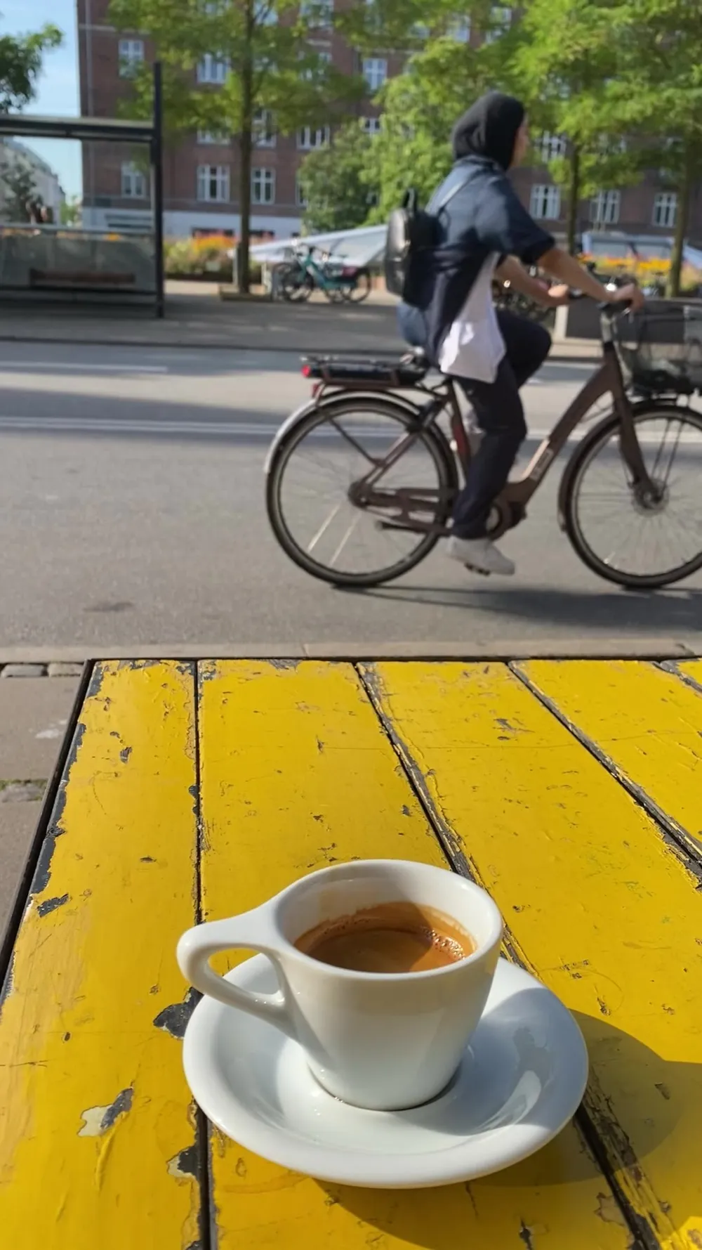 Ein frischer Espresso auf einem sonnengelben Café-Tisch